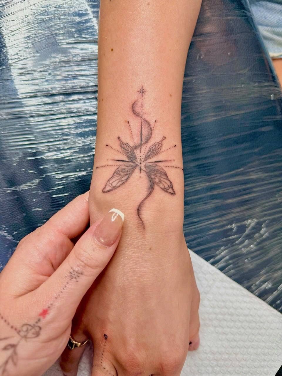 Fine-line butterfly snake wrist tattoo - Sisters Ink Tattoo Studio Da Nang